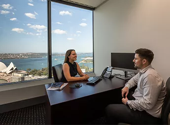 Professionals meeting in a fully equipped serviced office with breathtaking Sydney Harbour views.